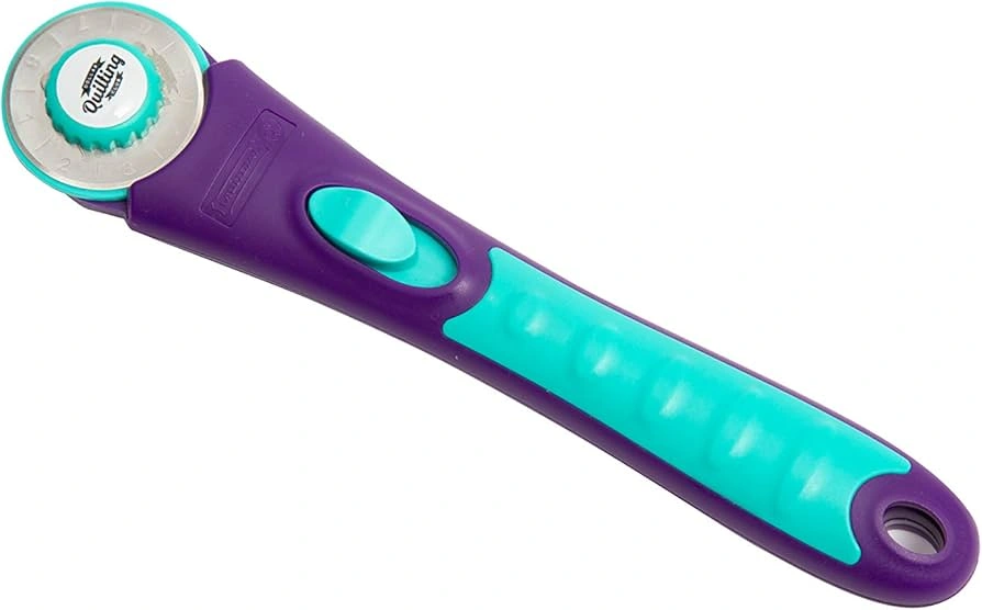 A rotary cutter being used to cut fabric with speed and precision on a cutting mat